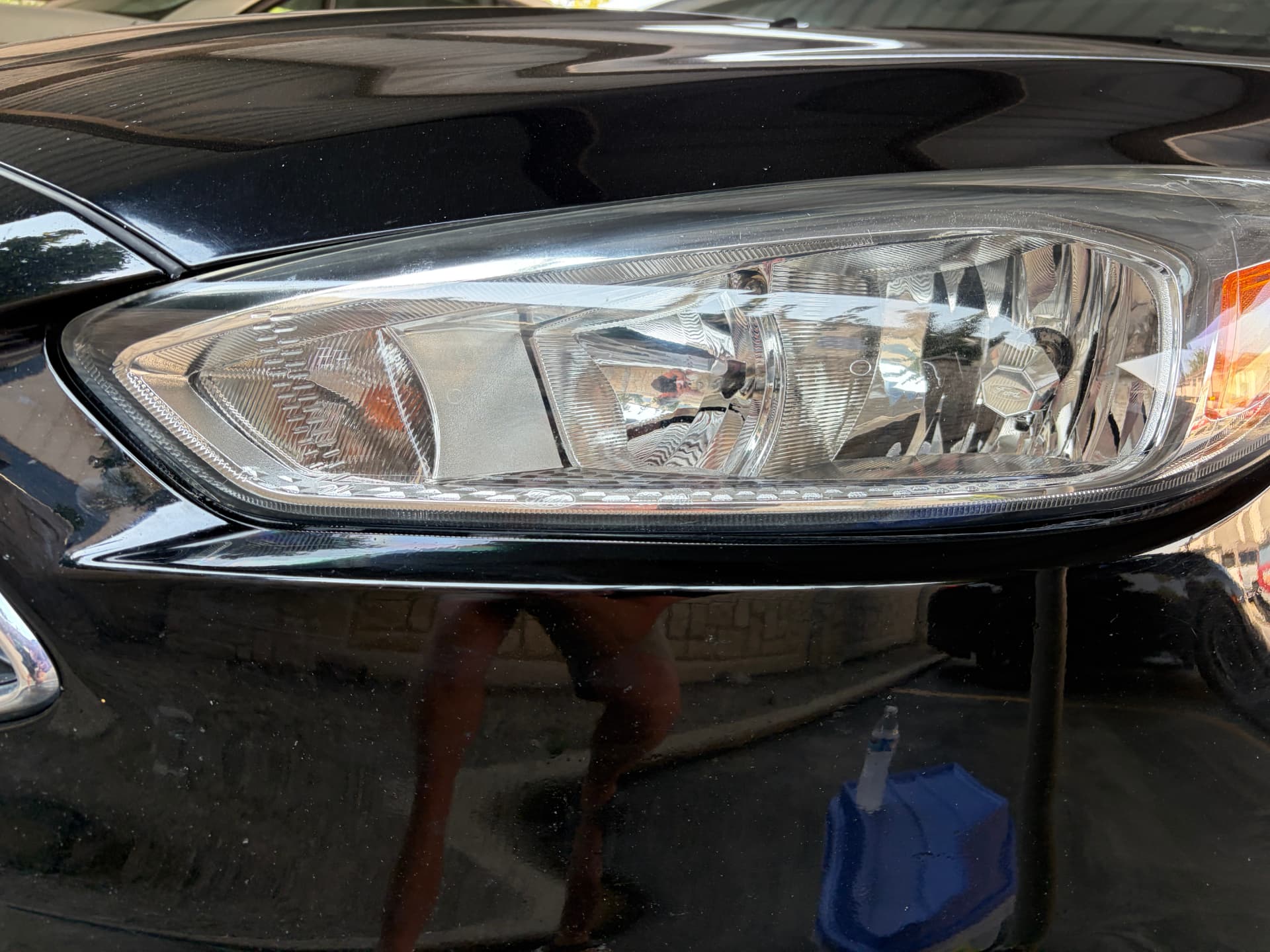 Clear headlight after restoration and ceramic coating — cloudy oxidized Ford headlight before restoration compared with the clear restored headlight in Lehi