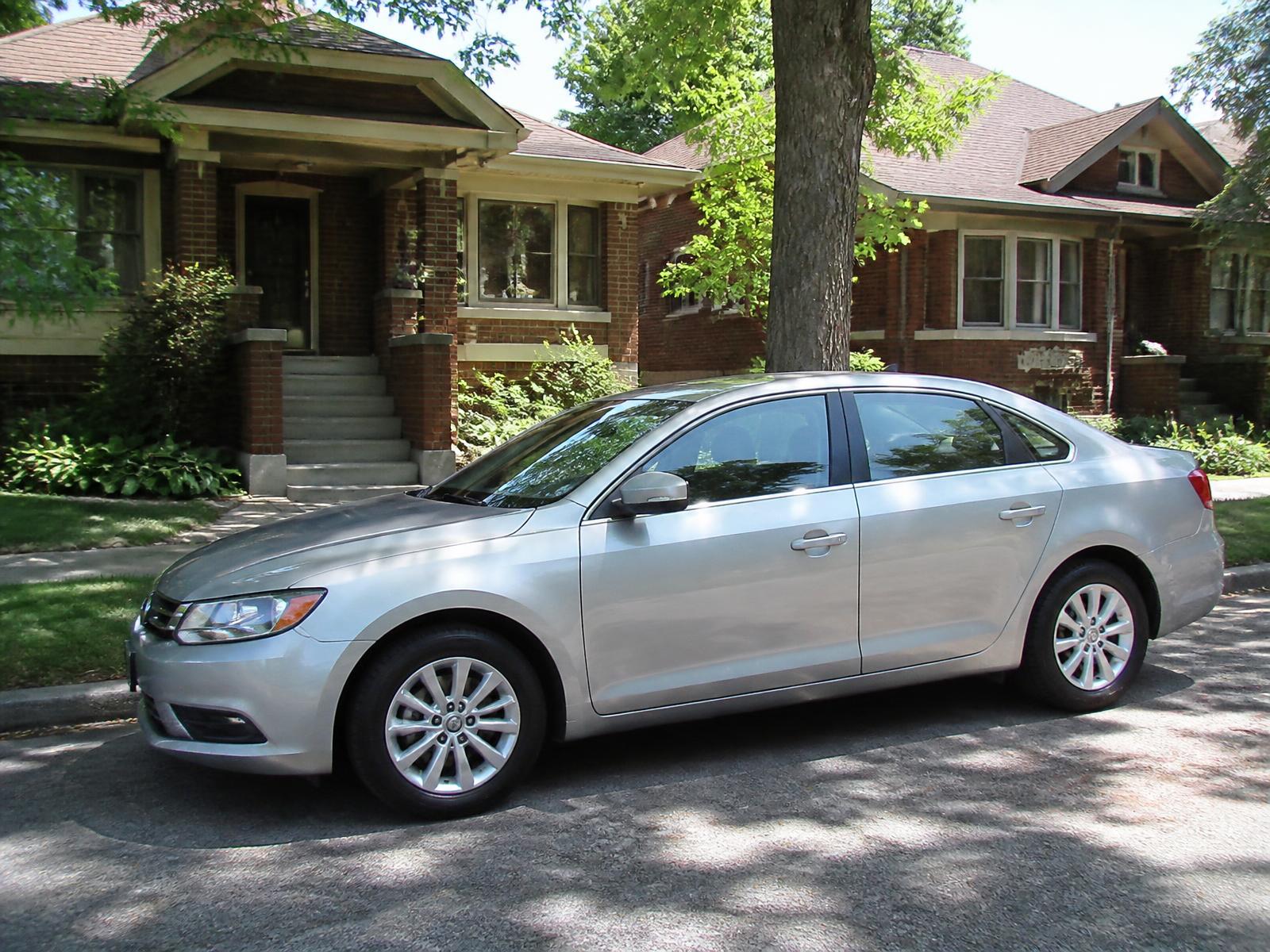 Professional headlight restoration near downtown Salt Lake City — sedan parked outside brick homes in an established city neighborhood on a bright sunny day