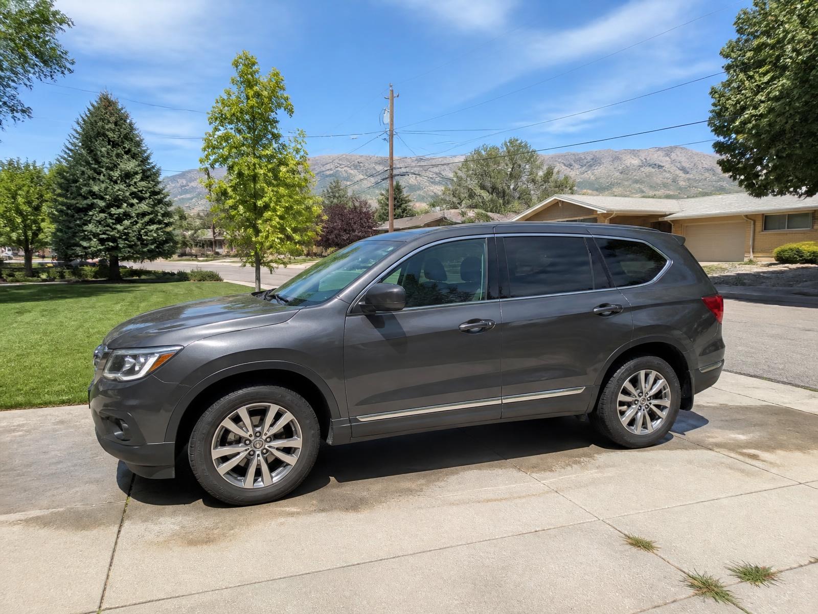 Professional headlight restoration near 3500 South — family SUV parked in a West Valley City residential driveway on a sunny day